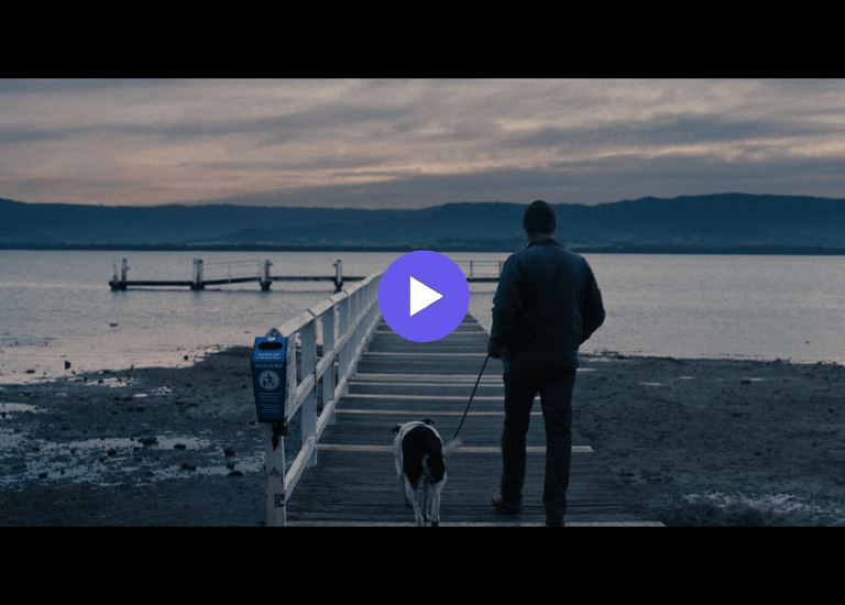 man and dog walking towards a jetty