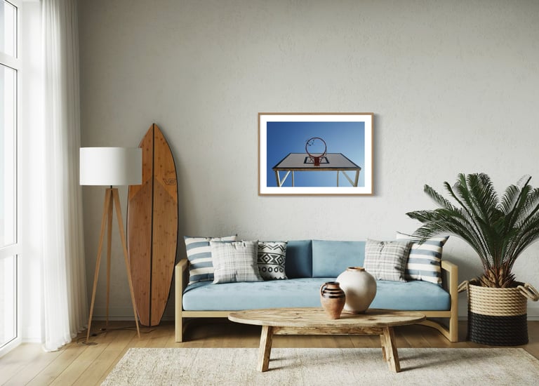 Living area with surfboard, blue sofa, and framed fine art photo, By ACAT Photos.