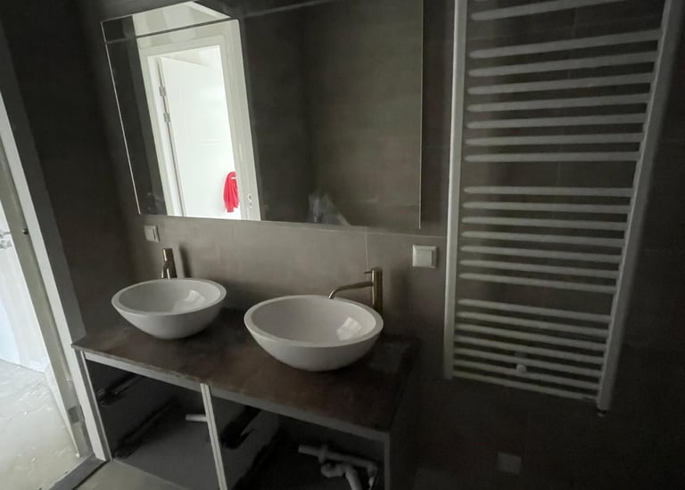 Moderne badkamer met dubbele opzetwastafel, grote spiegel en handdoekradiator in Rotterdam-Hoogvliet