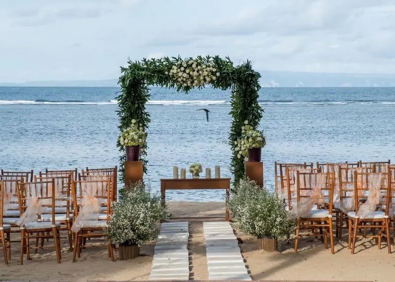 Beach wedding decoration with green drapes and tropical flowers by Pune wedding planning experts