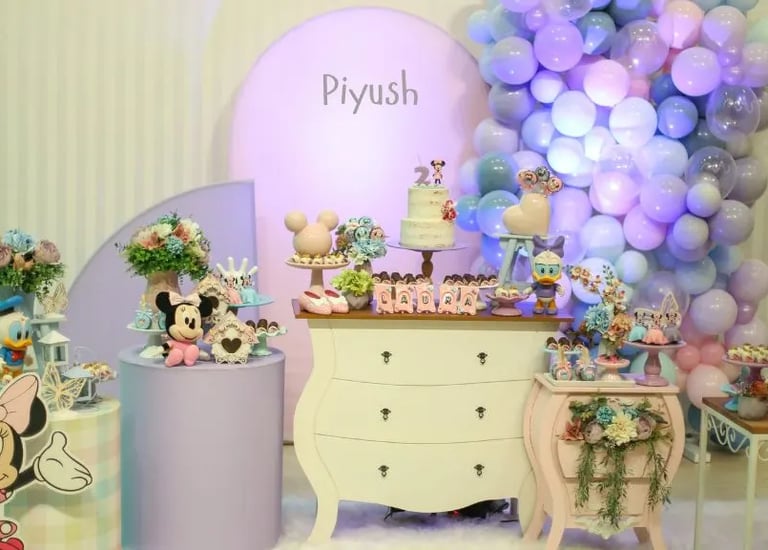 Colorful birthday party decoration with balloon arch, cake table, and LED lights by Pune party planner.