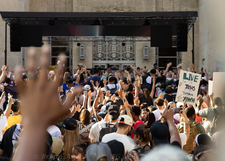 Group of people with hands raised during Houston Jesus March