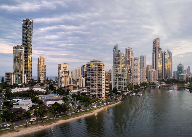 Aerial view of Meriton Suites Surfers Paradise facing the river, with the Gold Coast skyline in the background.