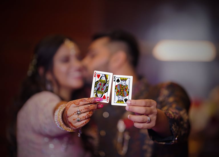 Couple holding cards and kissing each other while girl hold queen of heart and boy holds king