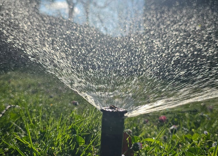 a sprinkler sprinkler sprinkles in the grass