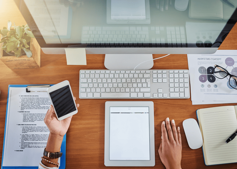 virtual assistant for dental clinics sitting at a desk with a tablet, mobile phone and pc 