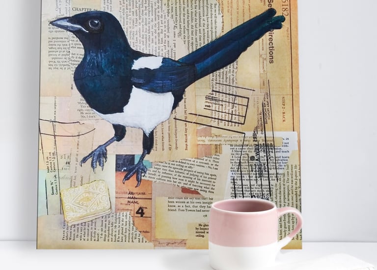 a mixed media painting of a magpie eating a custard cream biscuit by carolynne coulson