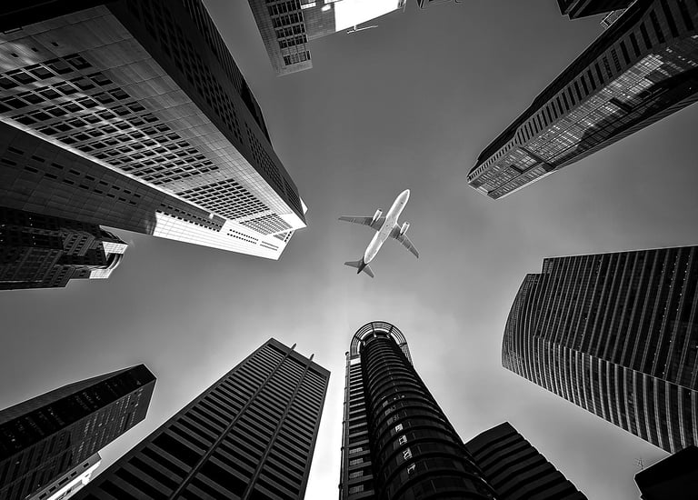 a plane flying over a city with tall buildings