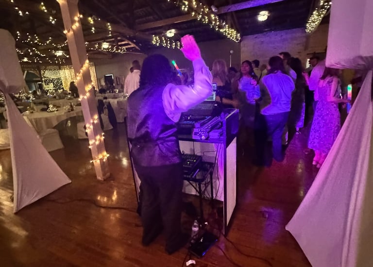 a dj spinning around a dj booth at a wedding