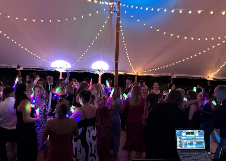 a group of people standing around a dj booth