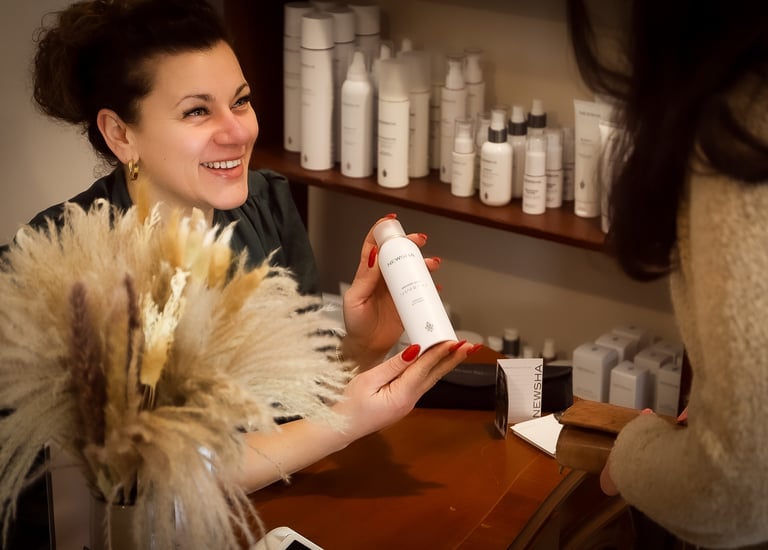 Eine Frau lächelt und hält eine Flasche Haarpflegeprodukte für Haarverlängerungen. Tressen, Bondings