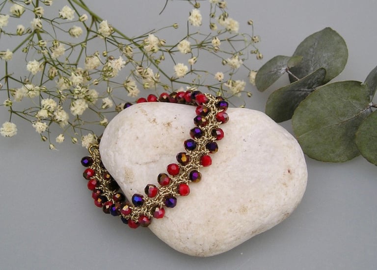 Un bracelet de perles rouges et violettes au crochet