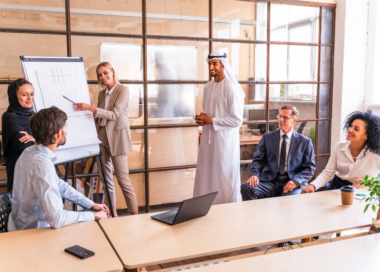 A diverse, cross-cultural team collaborates during a leadership training presentation.