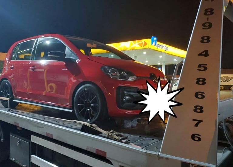 Guincho no posto carregando carro vermelho