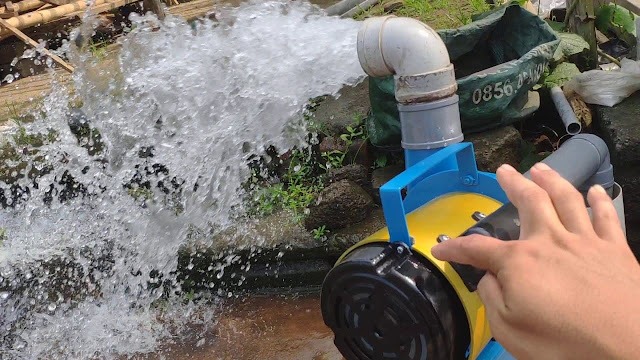 A portable electric water pump machine discharging a high-pressure stream for agricultural irrigation.