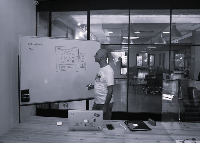 A project lead drawing a system diagram on a whiteboard