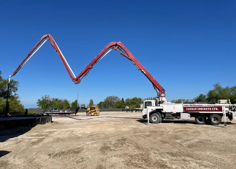 Concrete pump truck placing concrete at large construction site in Manitoba