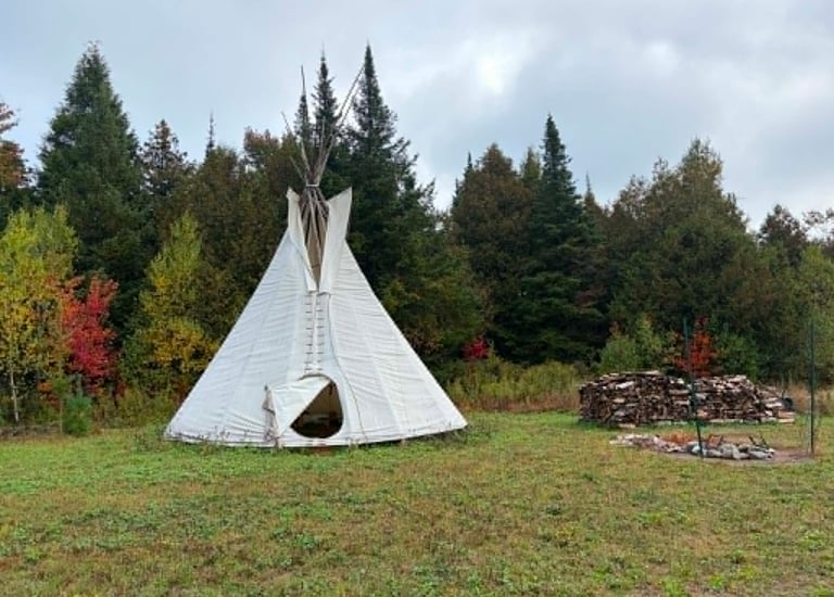 Tipi dans la prairie en bordure du boisée.