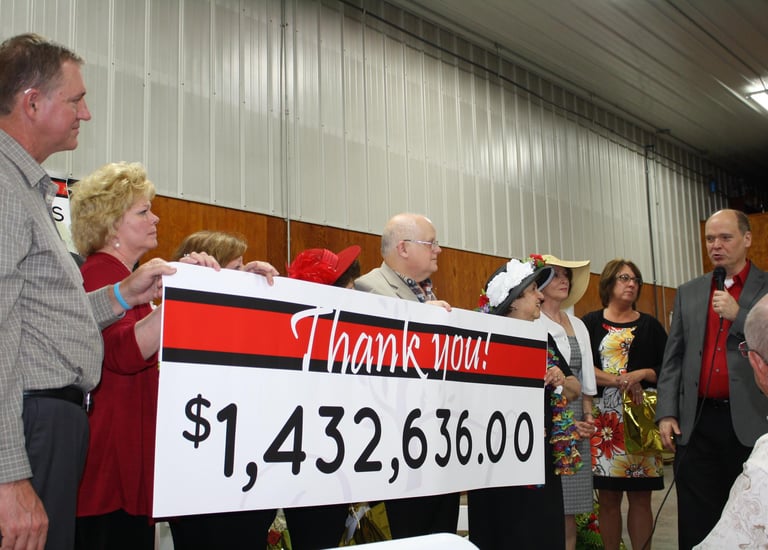 a man and woman standing in front of a sign that says thank you