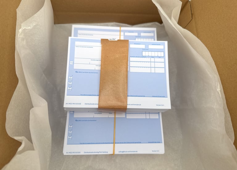 Bundled blue medical prescription forms for German pharmacies inside a shipping box with white tissue paper.