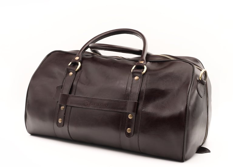 Geantă de voiaj din piele maro închis, fotografiată din față, centrată pe fundal alb.
