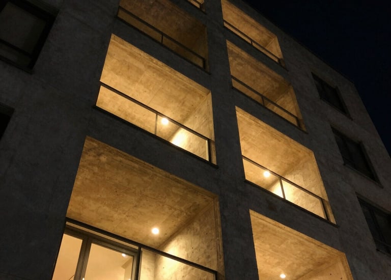 Modern renovated apartment exterior bathed in warm Greek sunlight.