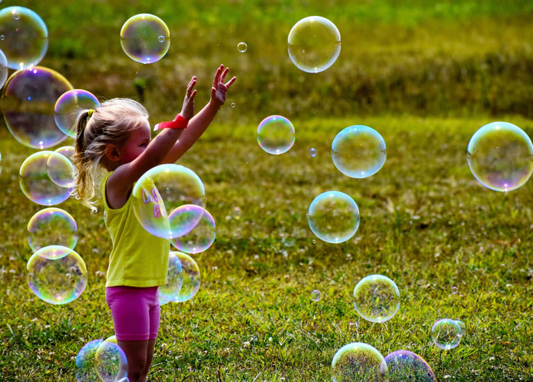 Little girl playing with bubbles