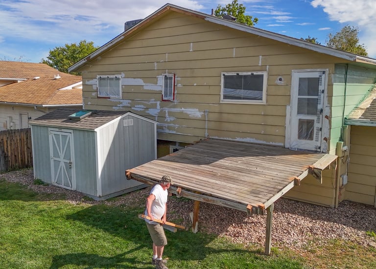Old wood deck removal and backyard site preparation by Denver contractor Brewer Construction at Iris Court.