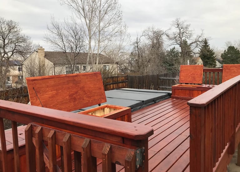 Finished outdoor living space in Golden with a Brewer Construction wooden deck, built-in benches, and hot tub.