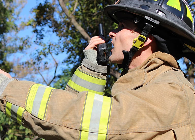 Firefighter observing a critical situation while reporting it via his S380 PoC radio