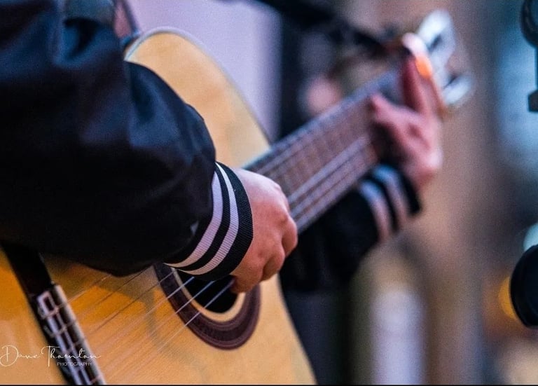 Moss.E playing the nylon-string guitar outside