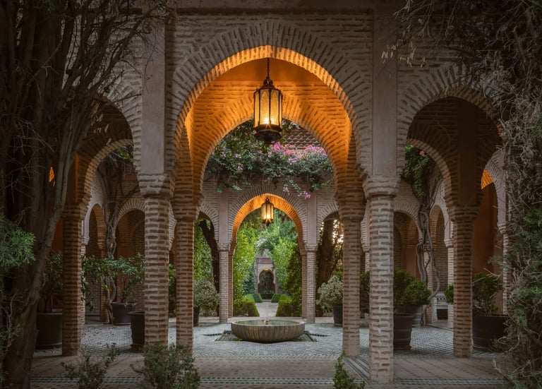 Lantern-lit Moorish colonnade with tiled floor and inner fountain