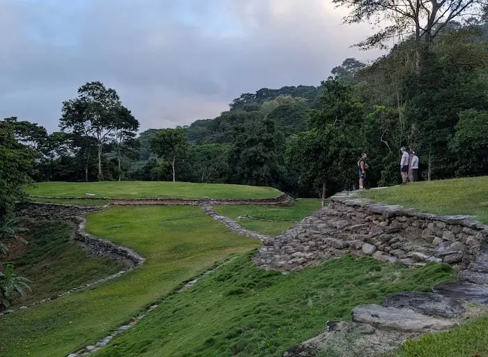 Ancient stone terraces and green circular platforms at Ciudad Perdida ruins in the Colombian jungle.