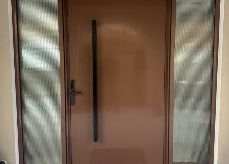 Modern brown main entrance door with fluted glass sidelites and black pull handle for luxury villa.