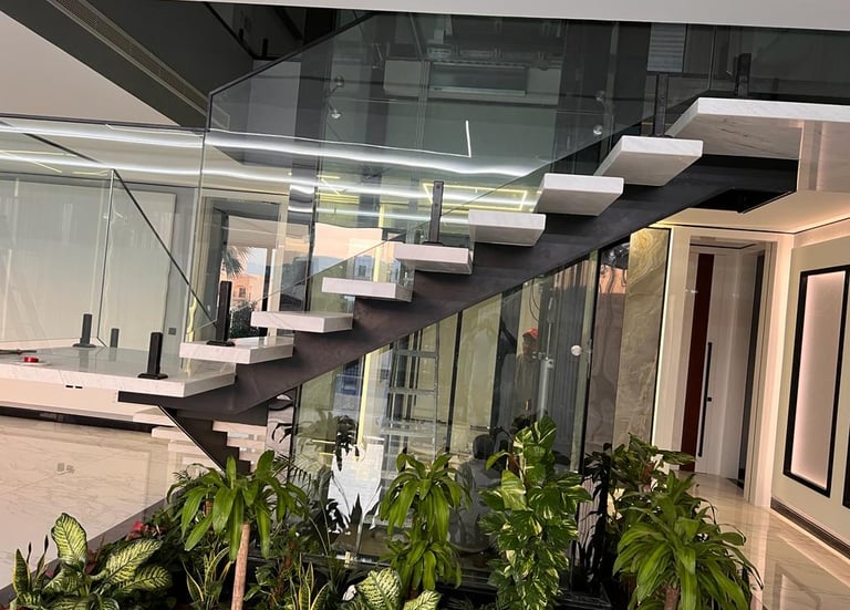 Modern structural steel staircase with frameless glass handrail and stainless steel fixings.