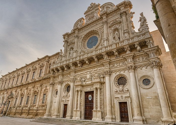 The ornate Baroque facade of Basilica di Santa Croce in Lecce, Italy, featuring intricate stone carvings.