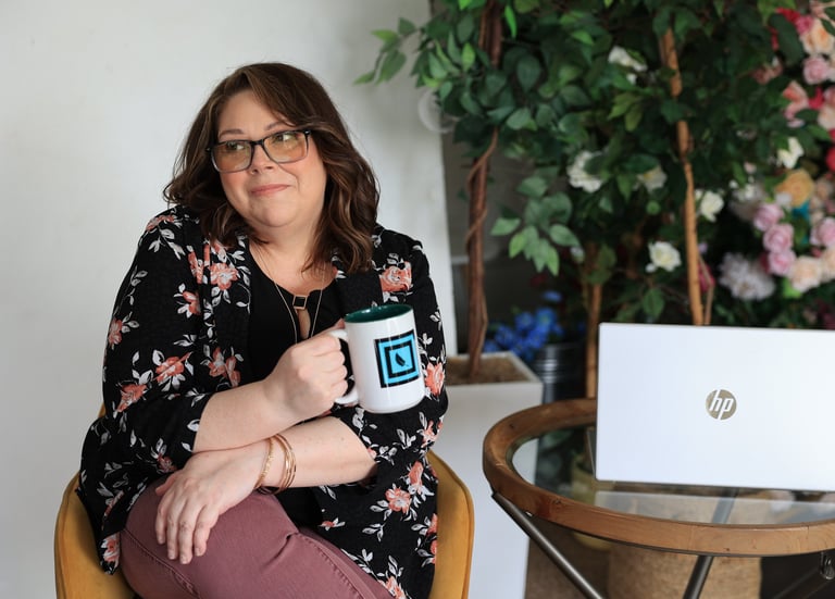 a woman sitting in a chair with a mug of coffee