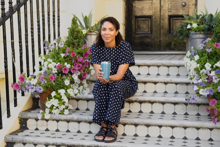 Lifestyle portrait of woman sitting on colourful steps in Brighton