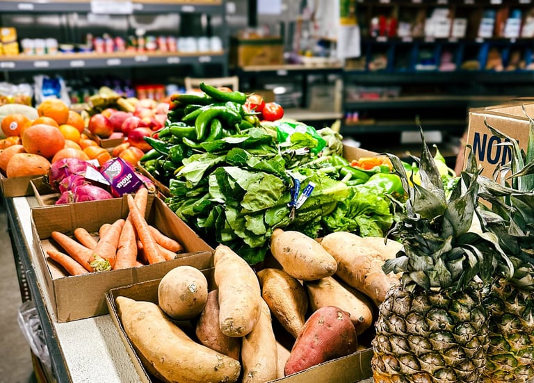 Pantry interior with table of fresh produce and shelves with canned and boxed food
