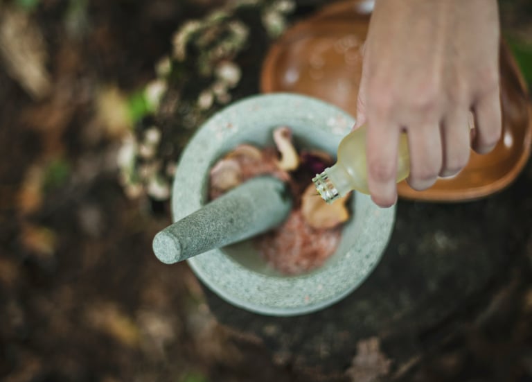 high angle photo of person pouring liquid from bottle inside mortar and pestle