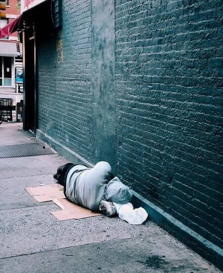 a person laying on the ground in front of a building