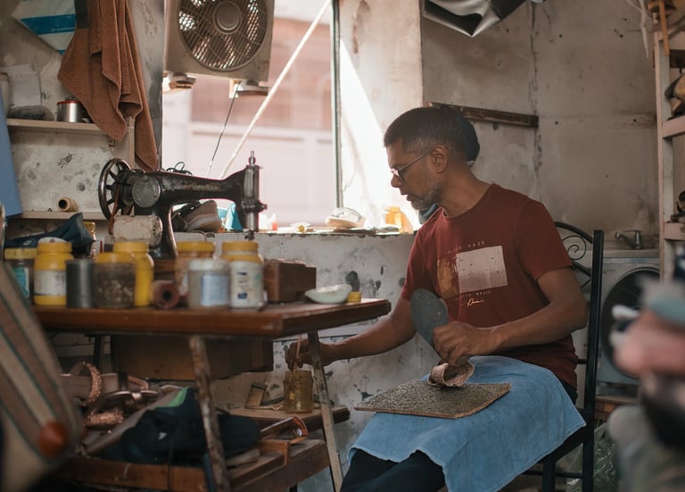 Cobbler and artisan at work in small workshop, Royal Road Mahebourg, Mauritius