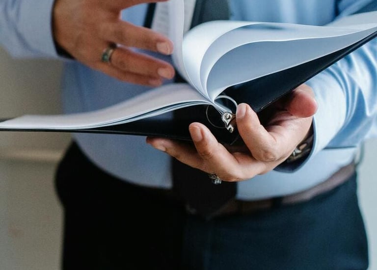 Un hombre de negocios hojea las páginas de una carpeta para gestionar documentos de oficina.