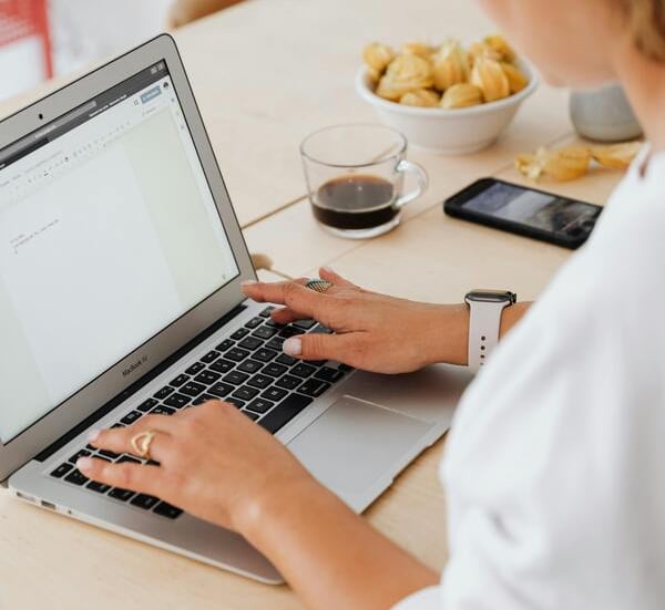 Mujer profesional escribiendo en un portátil en un escritorio