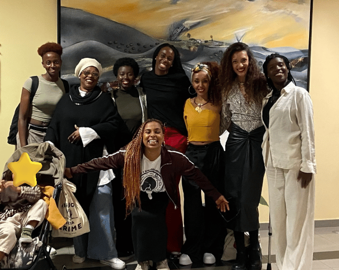 Un grupo de mujeres afro posando para la foto con un bebe en un carrito