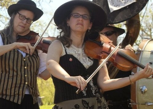 Band member playing violin during a live performance with Mazel Tov Kocktail Hour
