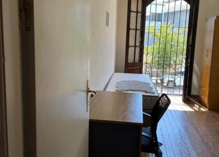 Habitación con escritorio mesa de luz y ventana