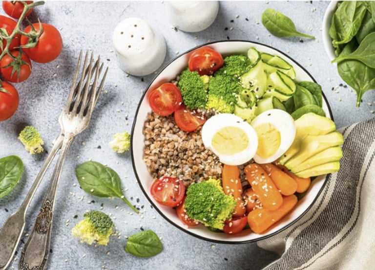 Colorful bowl with avocado, egg, broccoli, tomatoes, grains, and fresh greens for holistic nutrition