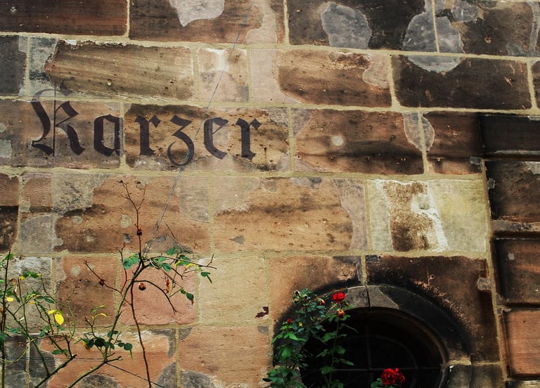 Historischer Karzer-Schriftzug an einer Sandsteinwand in Erlangen
