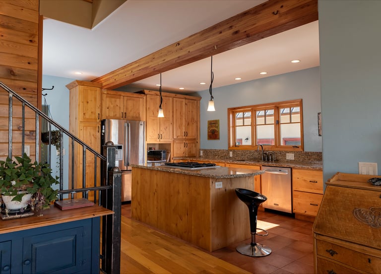a kitchen with a wooden floor and a staircase